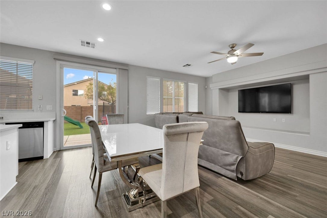 An open floorplan seamlessly connects the dining and living spaces over durable plank flooring.