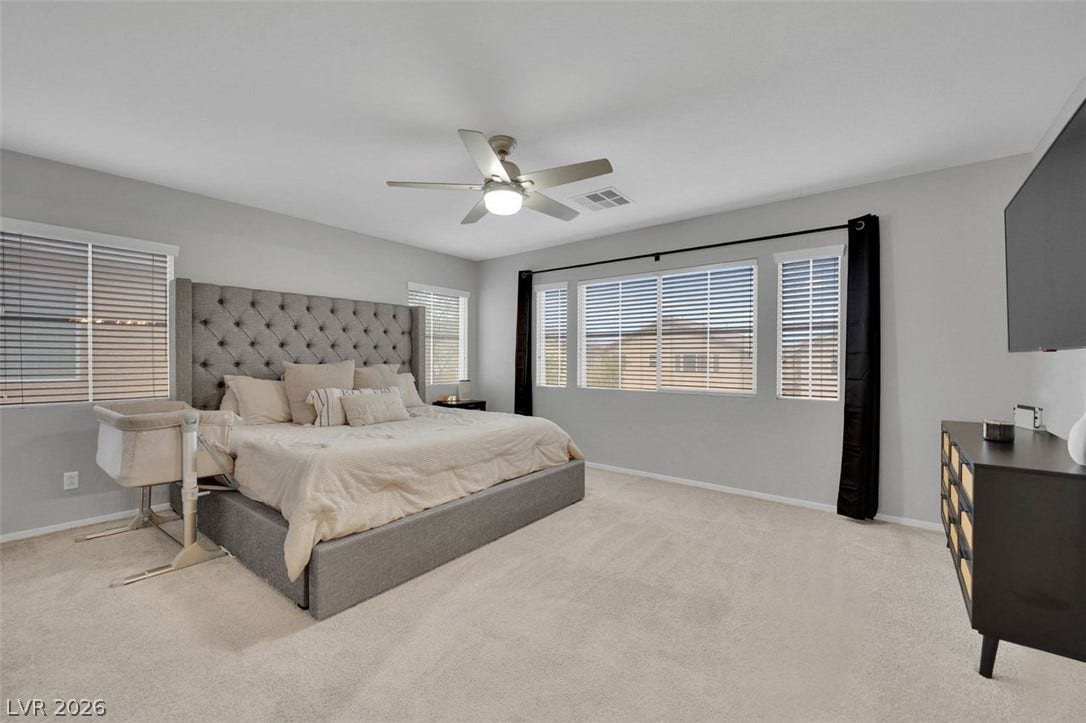 Generous window placements invite abundant natural light across this comfortable bedroom retreat.