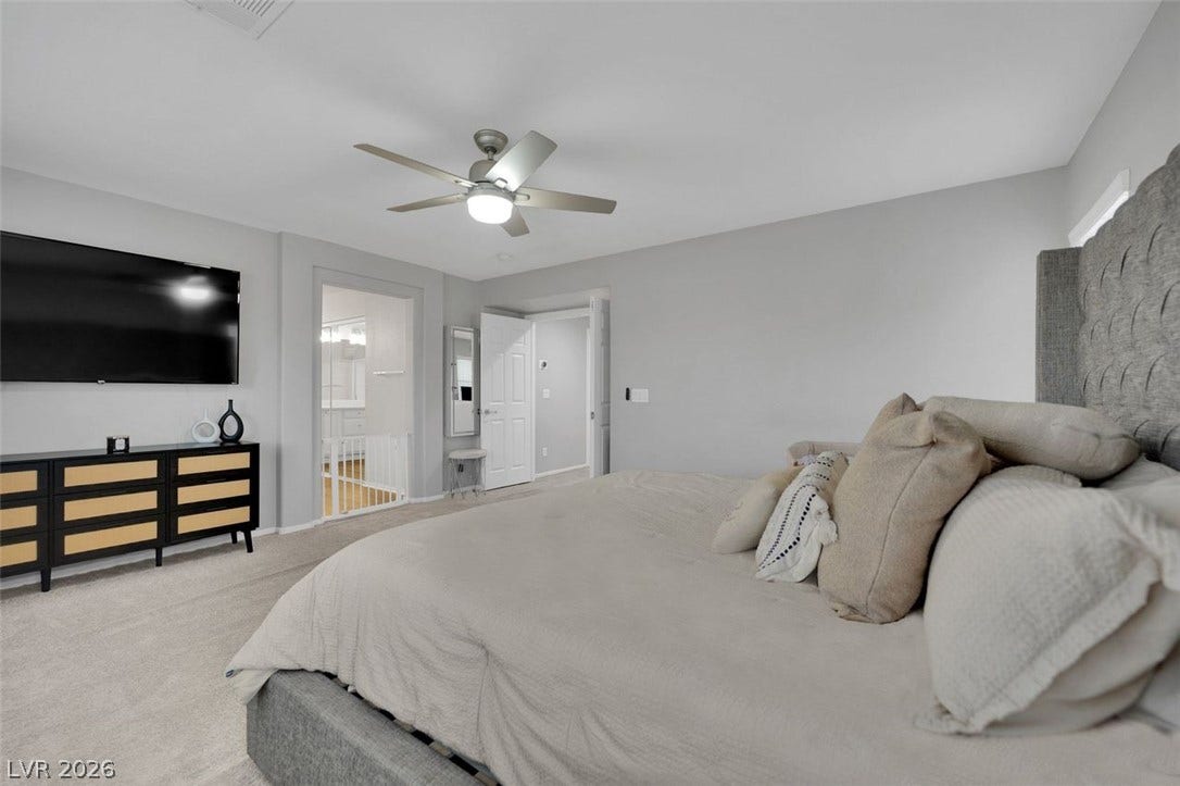 A spacious bedroom offers plush neutral carpeting and smooth walls under a clean white ceiling.