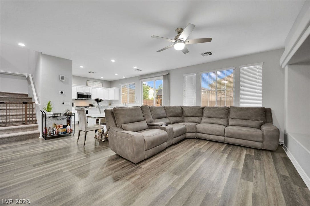 Clean lines and wood-style flooring flow through a bright open-concept living area.