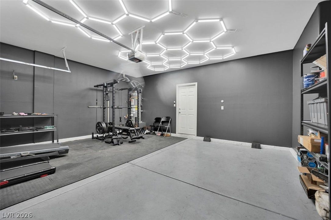Dramatic geometric overhead lighting highlights the finished concrete flooring in this versatile space.