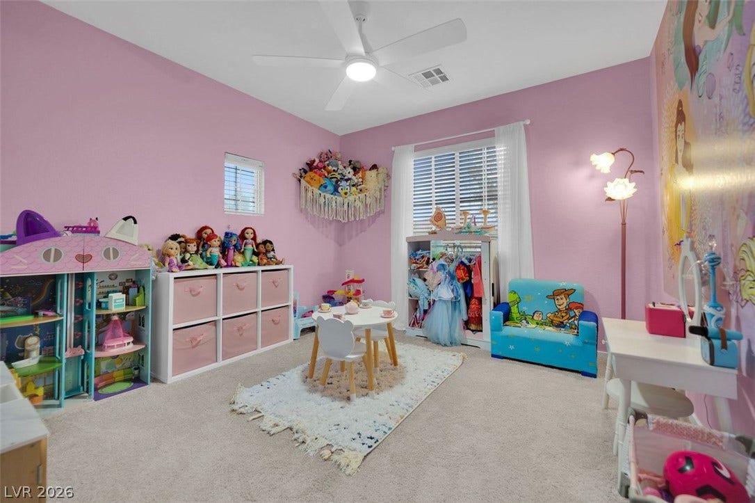 A spacious secondary bedroom features plush neutral carpeting and ample natural light from multiple windows.