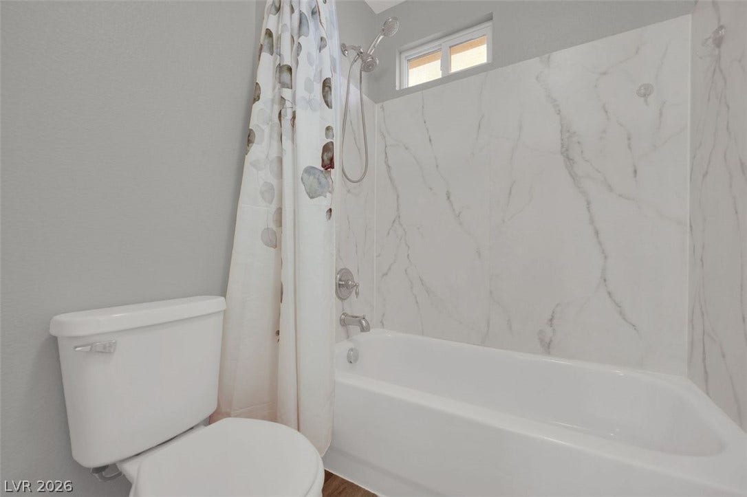 A sleek modern tub surround and high clerestory window bring light into this pristine bathroom.