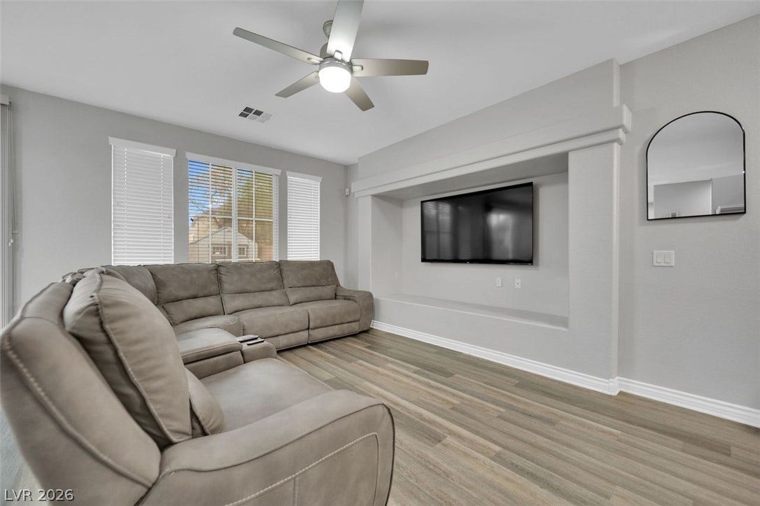 Generous windows fill this living space with natural light highlighting the durable wood-look flooring.