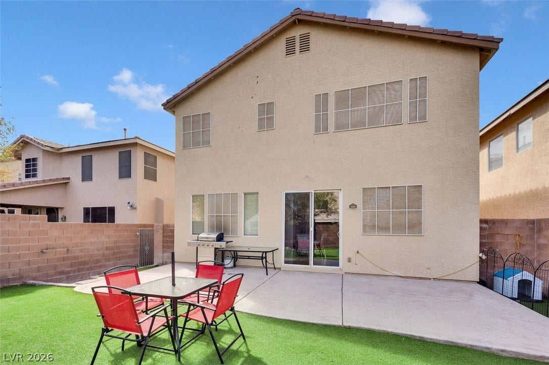 Concrete patio spaces overlook a low-maintenance yard enclosed by privacy block walls.