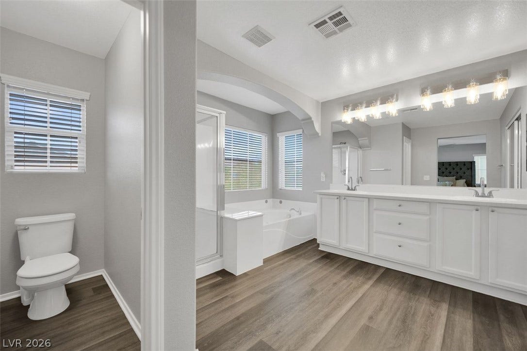 An expansive vanity, soaking tub, and separate shower anchor this well-appointed bathroom.