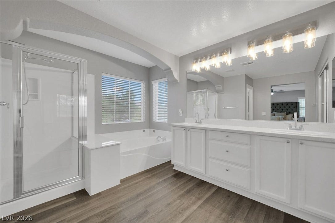 A spacious double vanity and a separate soaking tub highlight this master bathroom.