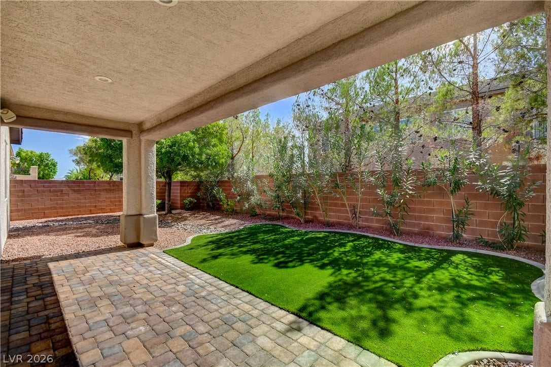 An inviting covered patio transitions seamlessly into a private, walled backyard.