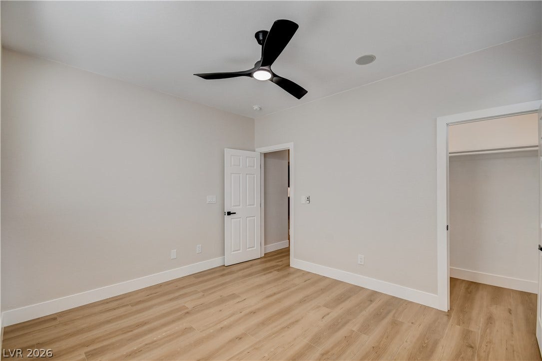 Smooth wood floors and crisp white trim run through this inviting bedroom space.