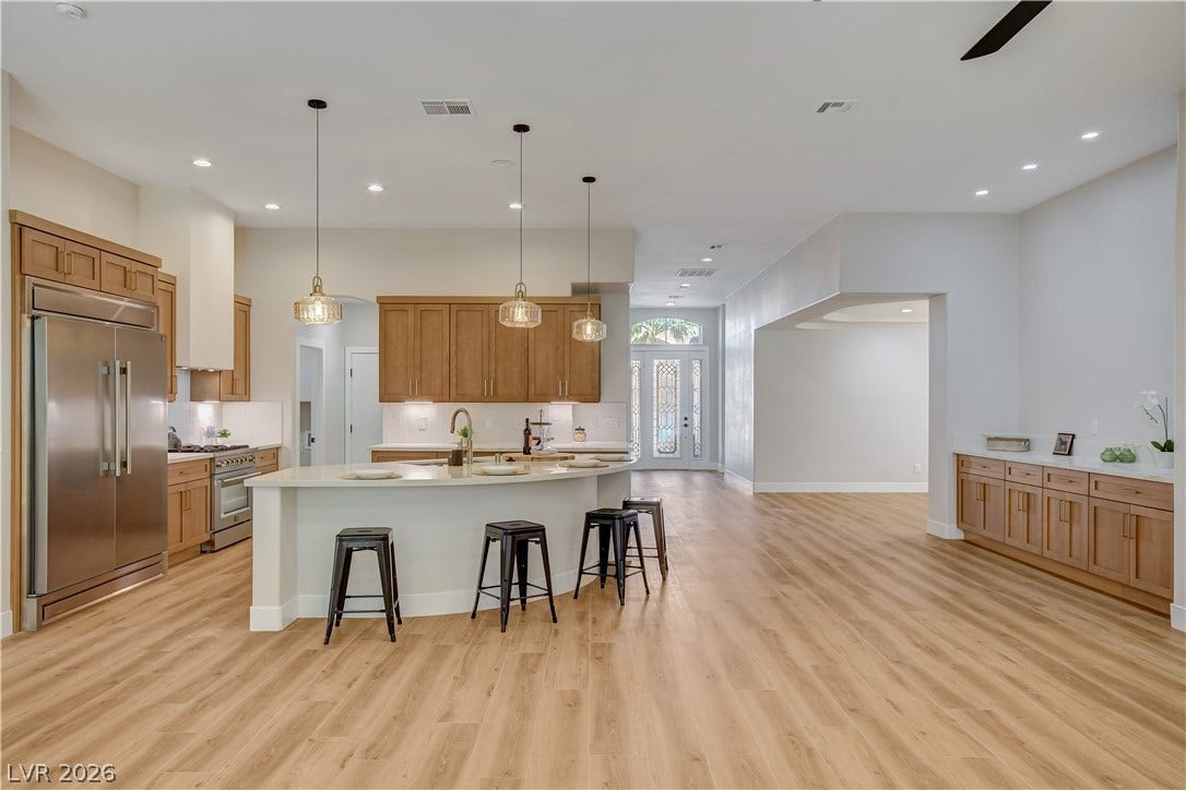 A spacious kitchen flows seamlessly into the bright open living area with modern wood flooring.