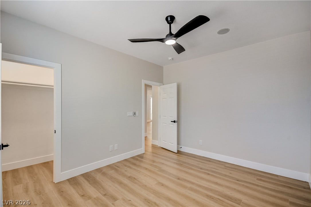 A minimalist design defines this versatile room featuring warm-toned wood floors and high ceilings.