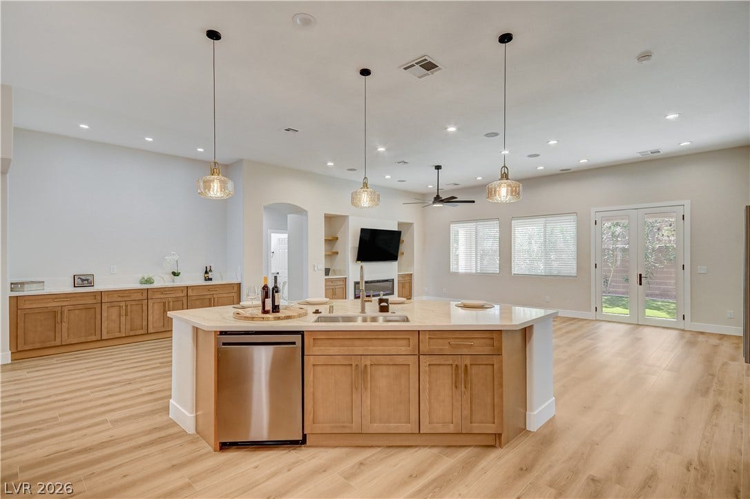 Gleaming hardwood floors and a spacious central island define this open-concept culinary space.