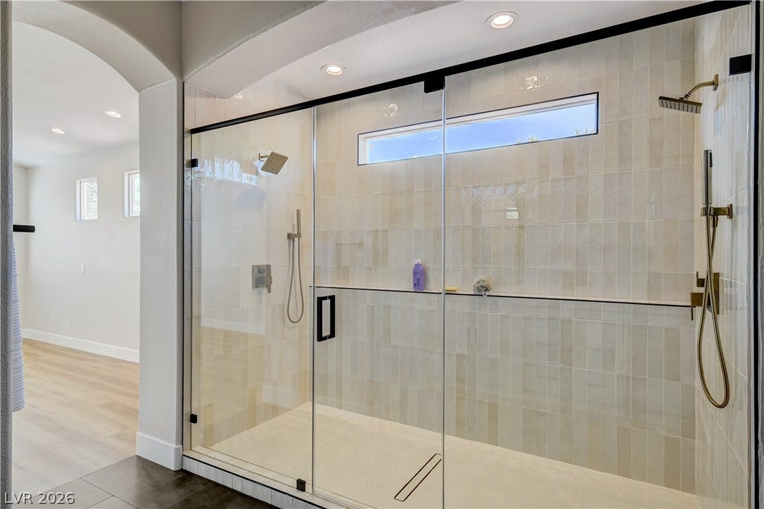 Floor-to-ceiling tiles and dual shower heads elevate this modern walk-in shower.