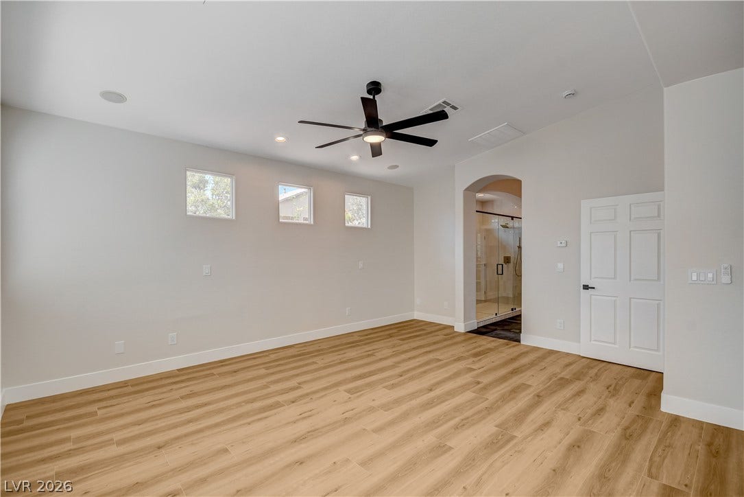 High ceilings and durable wood-look flooring define this light-filled main suite with bathroom access.
