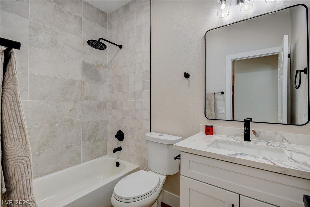 Elegant tile details and stone counters define this modern bathroom space.