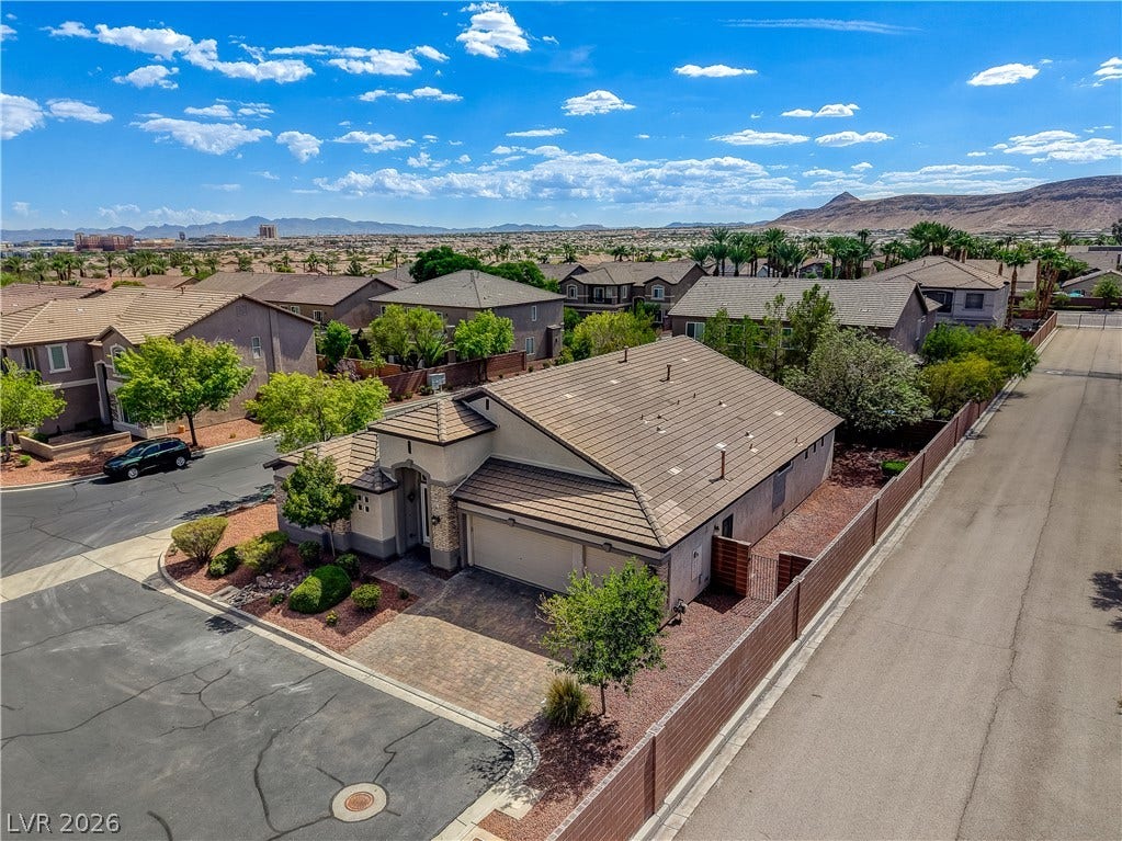 An aerial perspective showcases a tile-roofed home nestled within a quiet neighborhood landscape.
