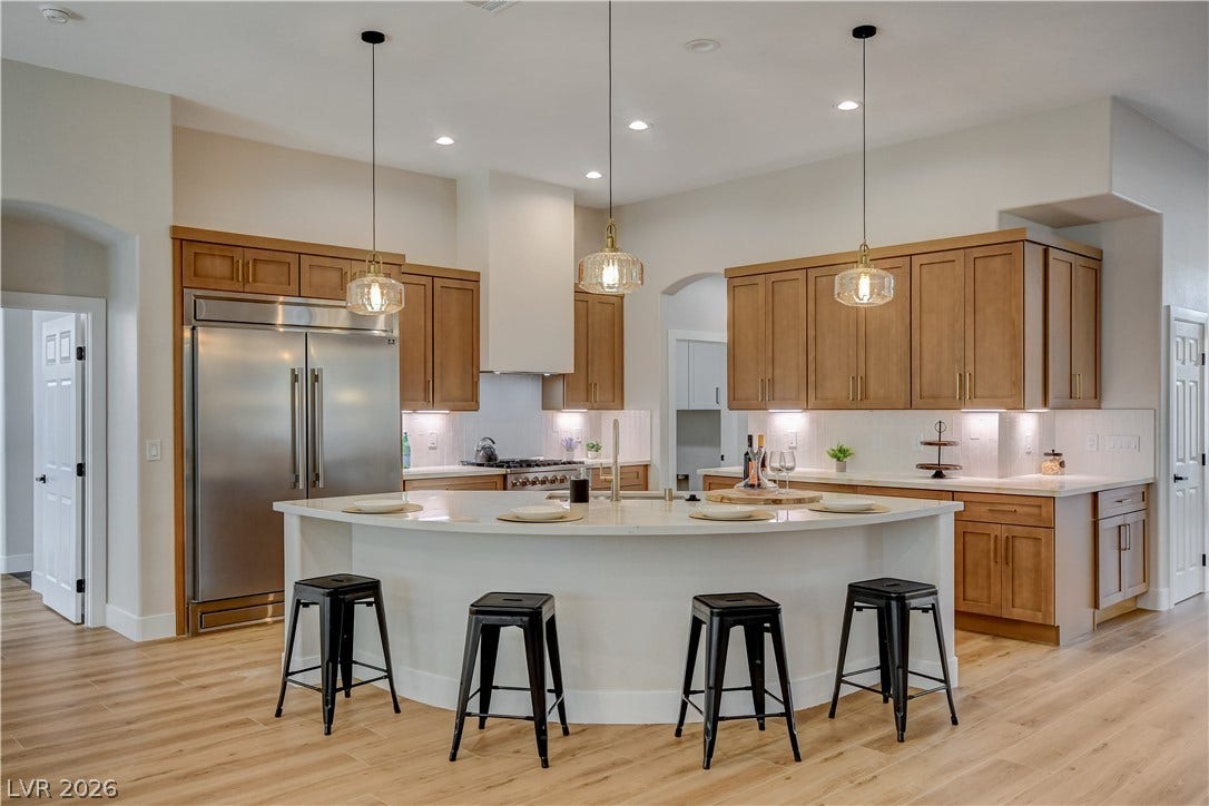 Warm wood cabinetry and a curved central island define this modern culinary workspace.