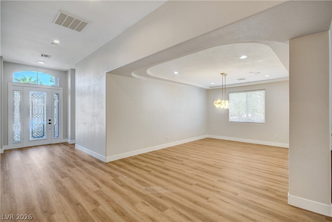 An open floorplan seamlessly connects the airy entryway to the formal dining area.