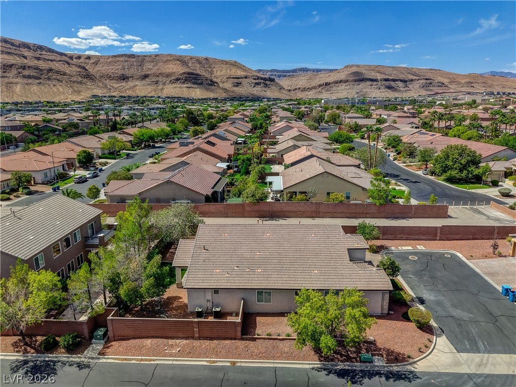 Rugged mountain ridges frame this desert neighborhood of tile-roofed homes.