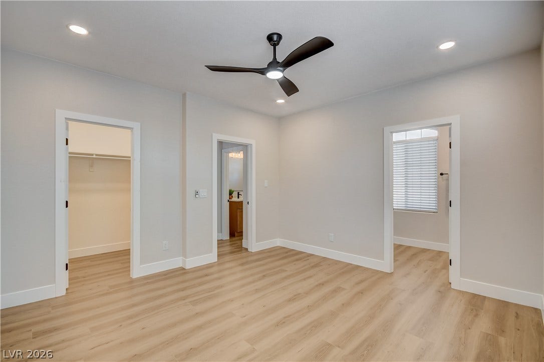 Smooth wood-look flooring and recessed lighting define this versatile modern bedroom layout.