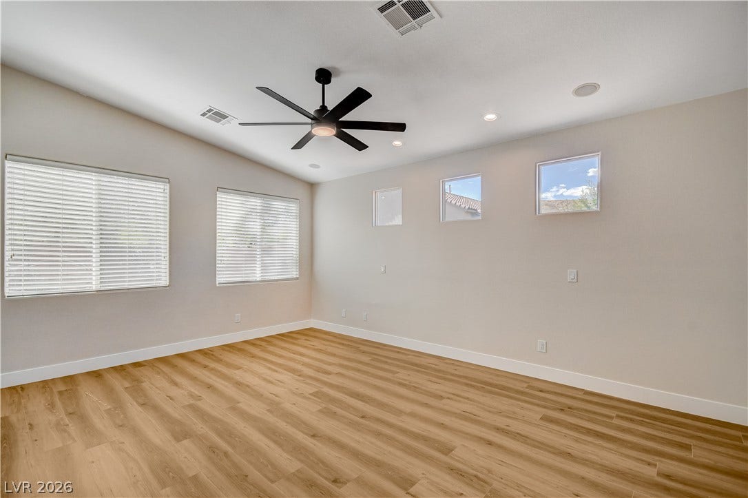 Warm wood floors and multiple windows define this versatile living space.
