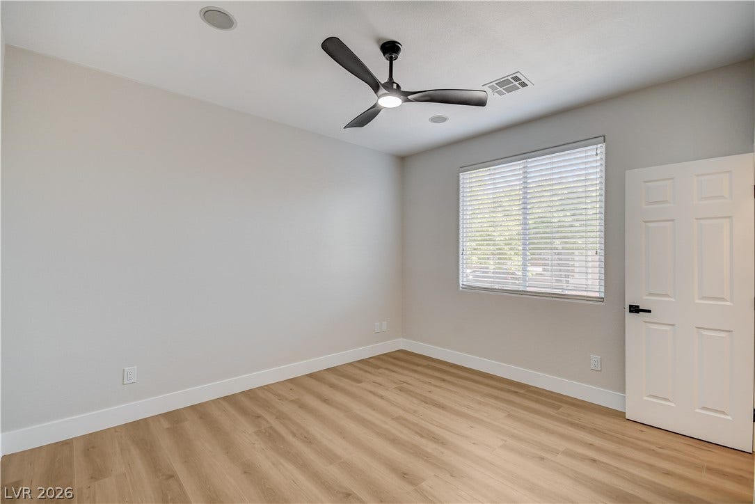 Smooth wood floors and tall baseboards ground this airy bedroom space.