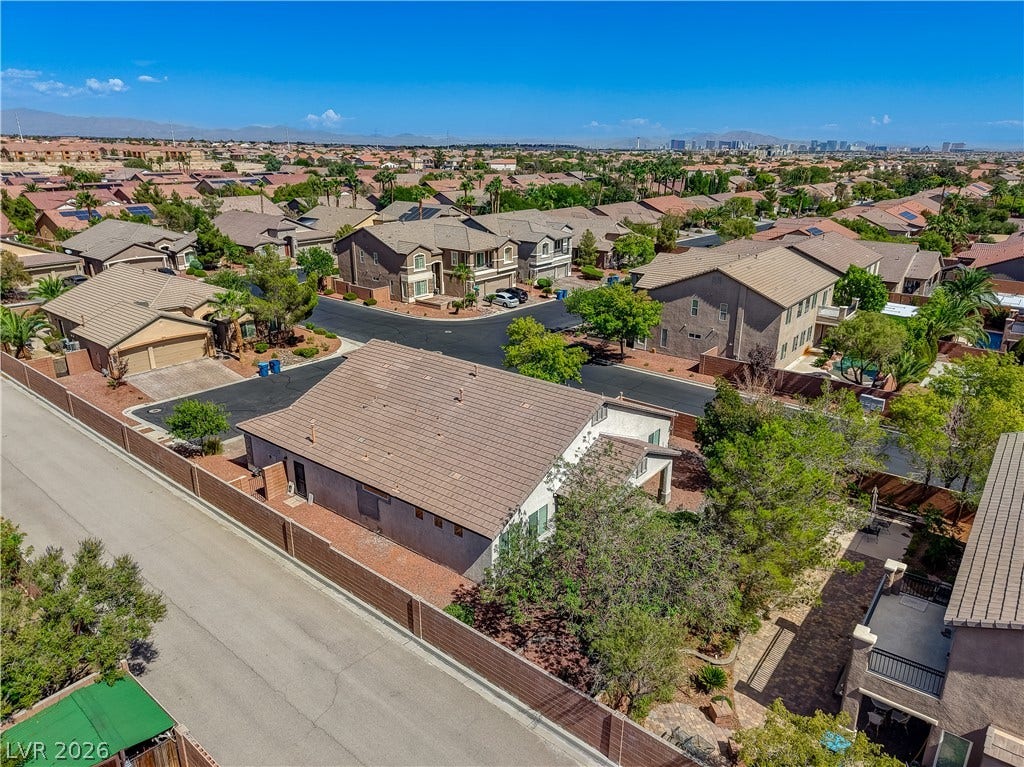 A high-angle perspective showcases the surrounding neighborhood under clear blue skies.