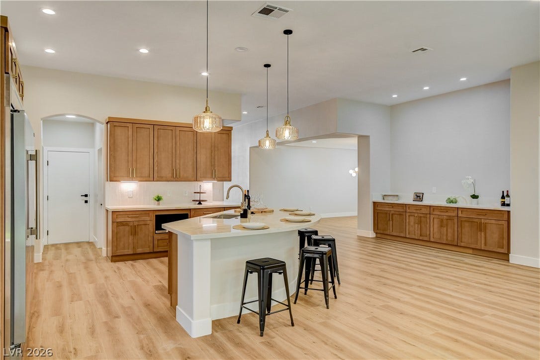 Gleaming wood floors pair beautifully with matching custom cabinetry and a curved central island.