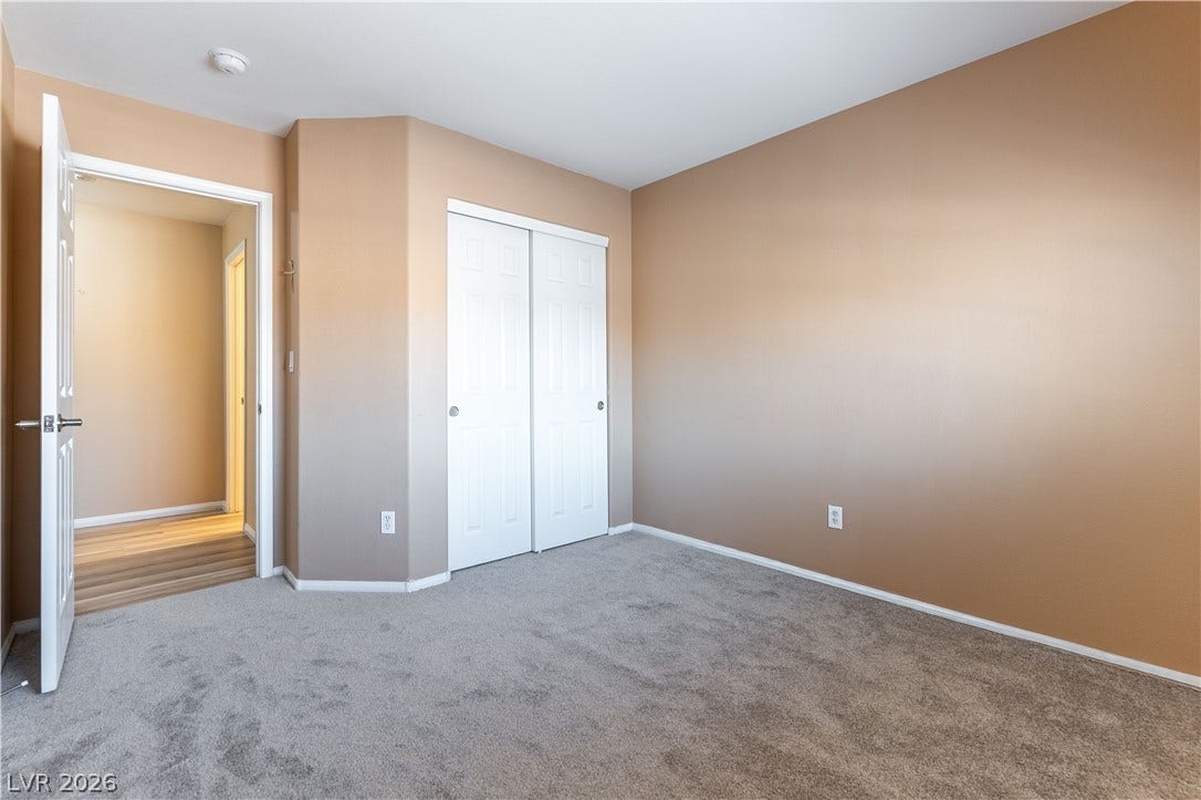 Plush carpeting underfoot and a convenient sliding closet door define this versatile bedroom space.