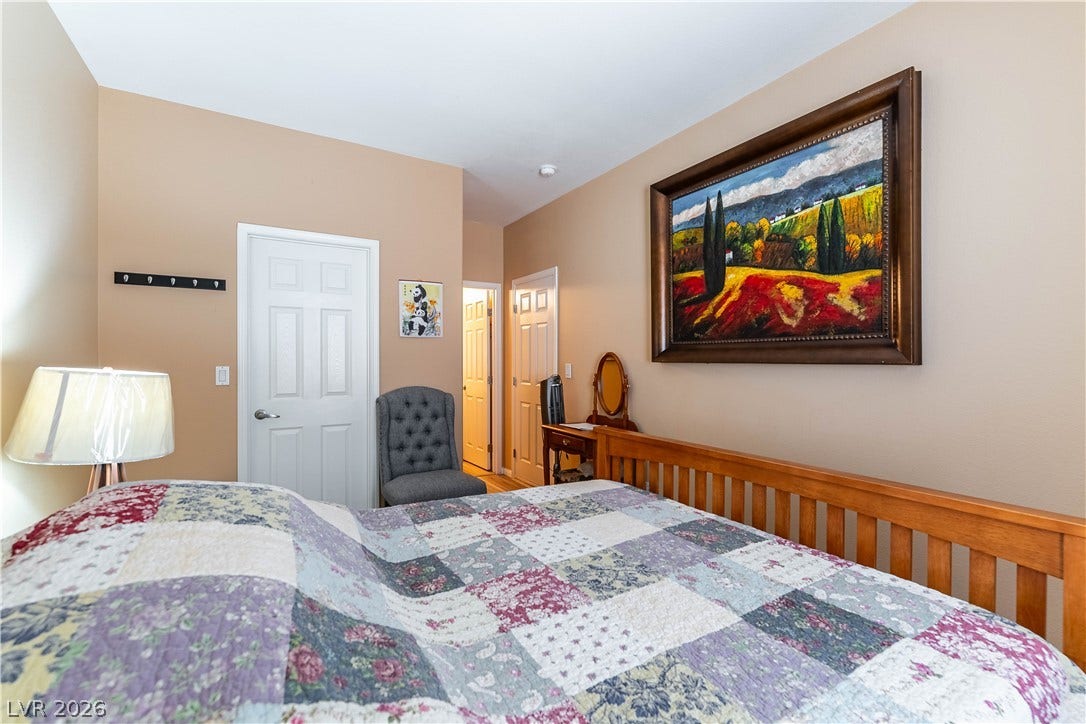 Smooth plaster walls and warm wood flooring define this inviting bedroom space.
