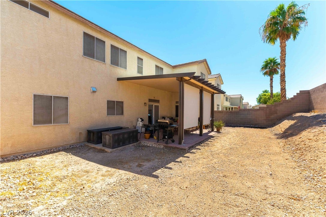 An expansive backyard features a covered patio and low-maintenance desert landscaping.