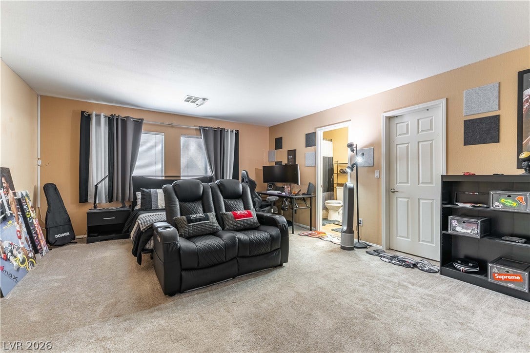 An attached bathroom and wall-to-wall carpeting complete this versatile secondary bedroom setup.