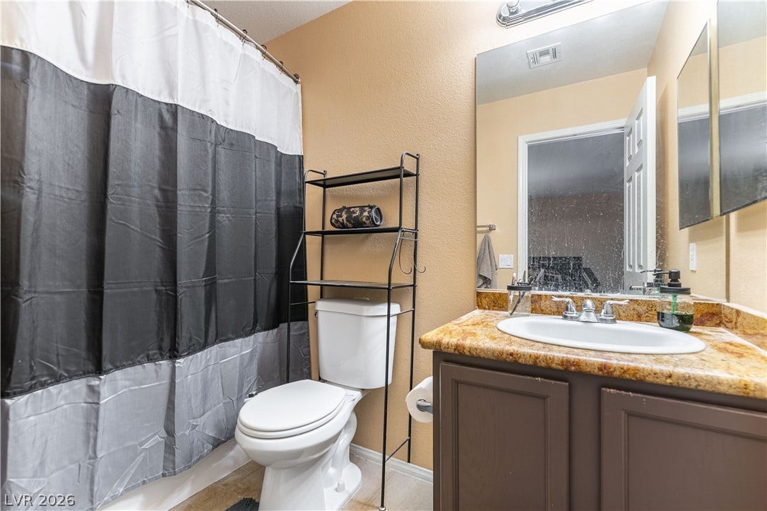 Richly patterned stone countertops elevate the vanity area in this classic bathroom space.