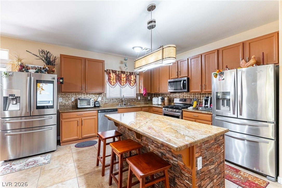 Gleaming stone countertops and warm wood cabinetry define this expansive kitchen space.