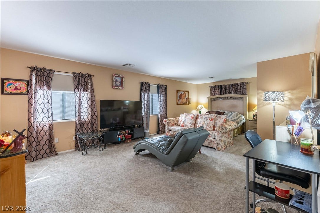 Plush wall-to-wall carpeting and multiple large windows create a comfortable, inviting living space.