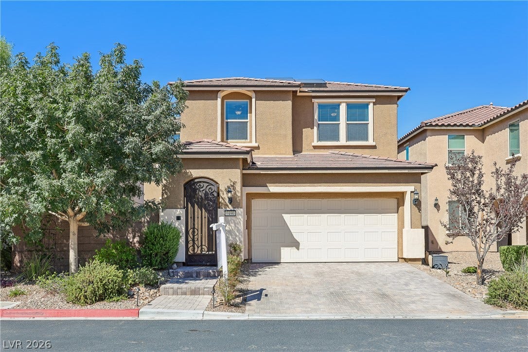 9490 Wild Valley Avenue, Las Vegas, NV 89148 Mediterranean-inspired stucco architecture defines this elegant two-story residence featuring a paved driveway.