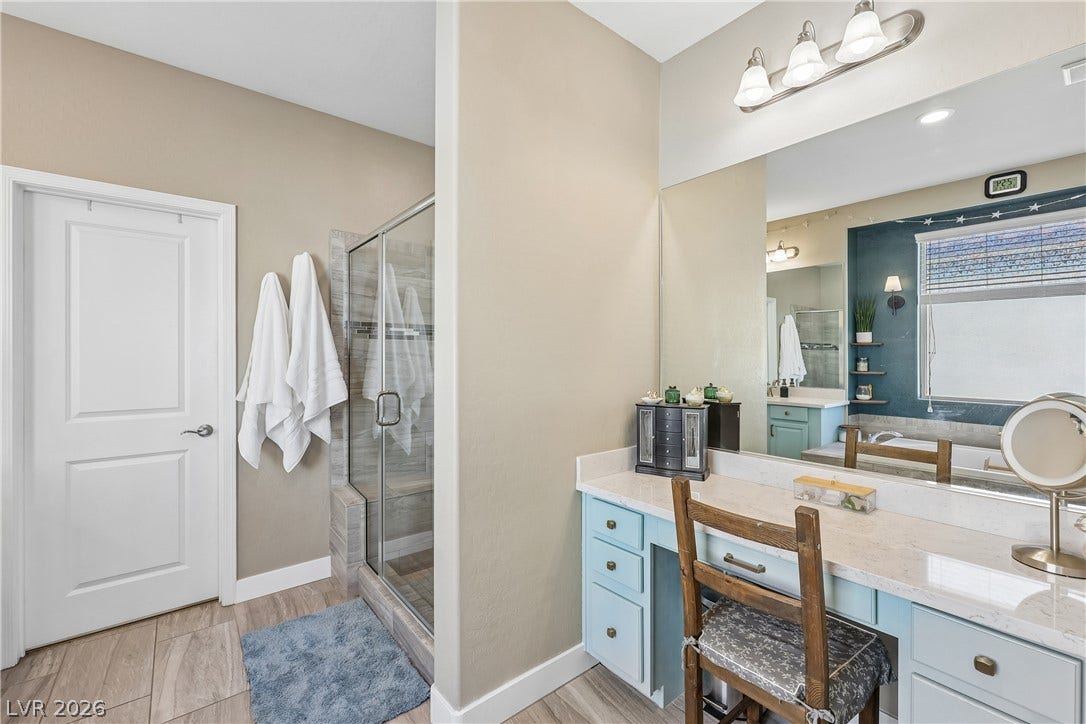 9490 Wild Valley Avenue, Las Vegas, NV 89148 A spacious vanity area with built-in cabinetry sits adjacent to a glass-enclosed walk-in shower.