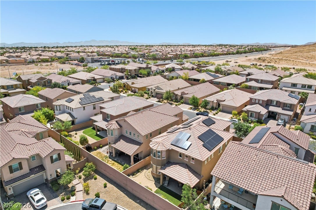9490 Wild Valley Avenue, Las Vegas, NV 89148 An aerial view showcases a peaceful suburban neighborhood tucked beneath a vast blue sky.