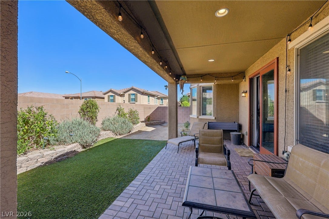 9490 Wild Valley Avenue, Las Vegas, NV 89148 A covered patio lined with pavers opens to a private backyard containing a neat lawn.