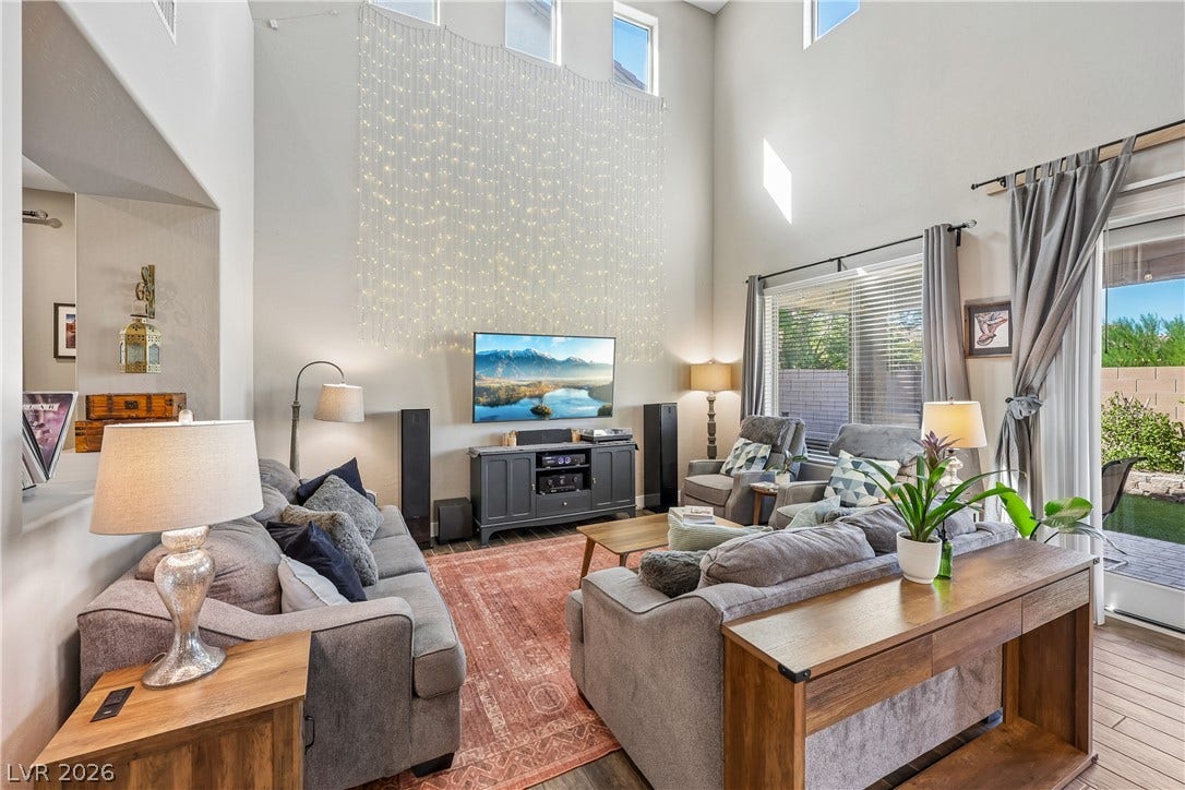9490 Wild Valley Avenue, Las Vegas, NV 89148 Soaring ceilings and tall windows illuminate a spacious, light-filled gathering room.