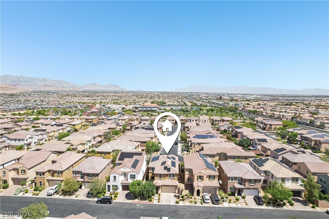9490 Wild Valley Avenue, Las Vegas, NV 89148 An aerial perspective showcases the neighborhood layout under clear blue skies.