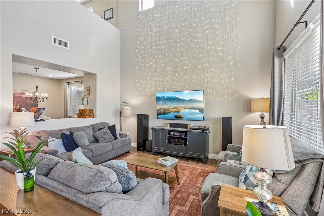 9490 Wild Valley Avenue, Las Vegas, NV 89148 High ceilings and tall windows bring an airy feel to this open-concept living area.