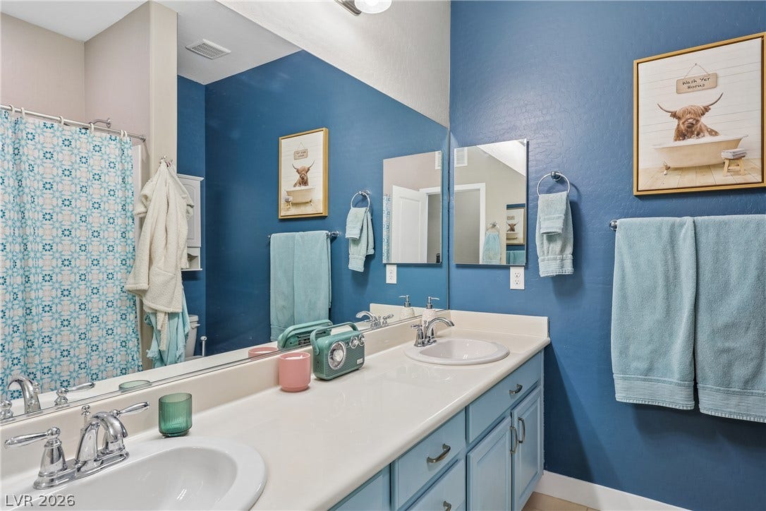 9490 Wild Valley Avenue, Las Vegas, NV 89148 Double vanities with white undermount sinks integrate seamlessly into this well-designed bathroom.
