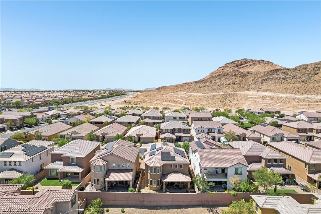 9490 Wild Valley Avenue, Las Vegas, NV 89148 Scenic mountain vistas overlook a peaceful suburban neighborhood of tile-roofed homes.