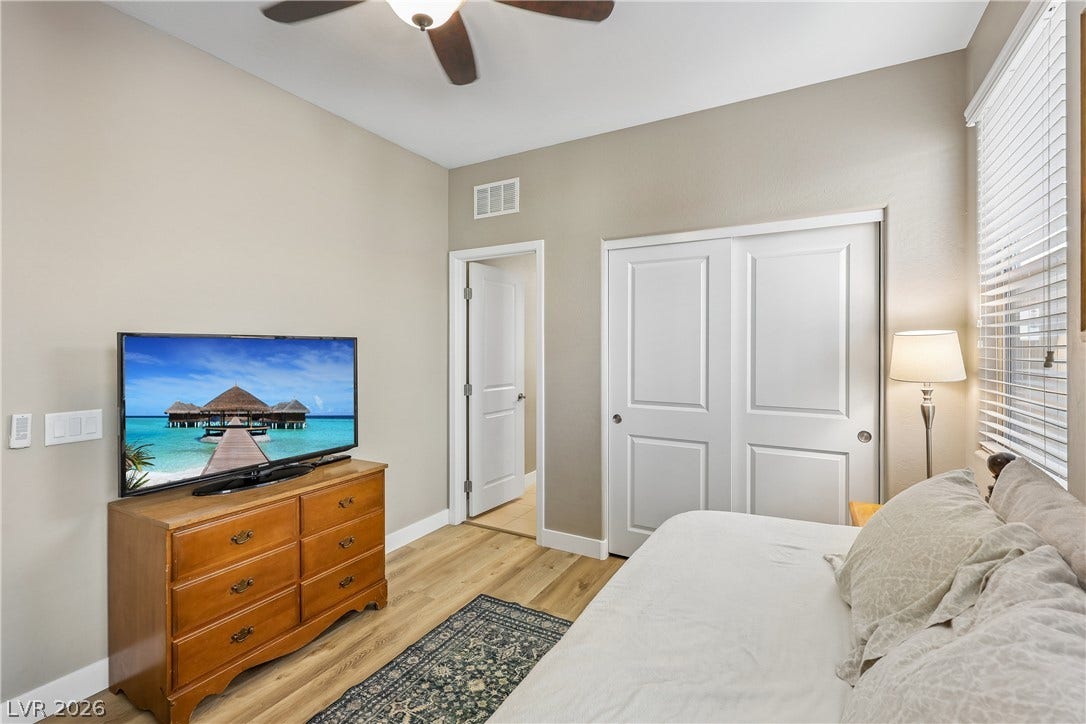 9490 Wild Valley Avenue, Las Vegas, NV 89148 Smooth wood flooring and a large window enhance this welcoming private bedroom space.