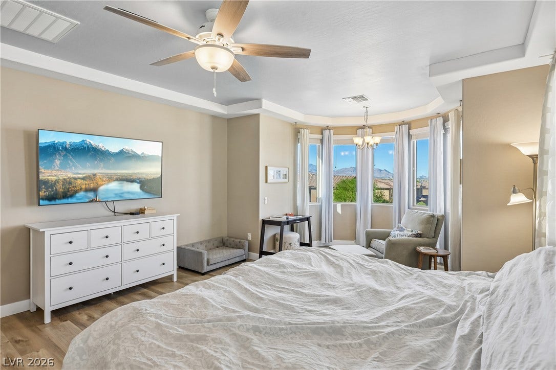 9490 Wild Valley Avenue, Las Vegas, NV 89148 A tray ceiling and bay window define this airy bedroom space.