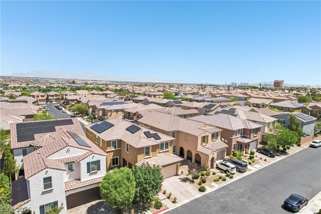 9490 Wild Valley Avenue, Las Vegas, NV 89148 An aerial perspective reveals a serene neighborhood street lined with tiled roofs and paved driveways.