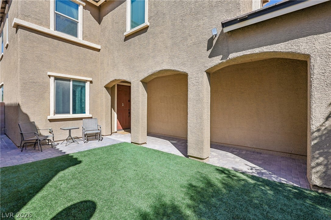 9490 Wild Valley Avenue, Las Vegas, NV 89148 An arched covered patio overlooks the private backyard with a green lawn.