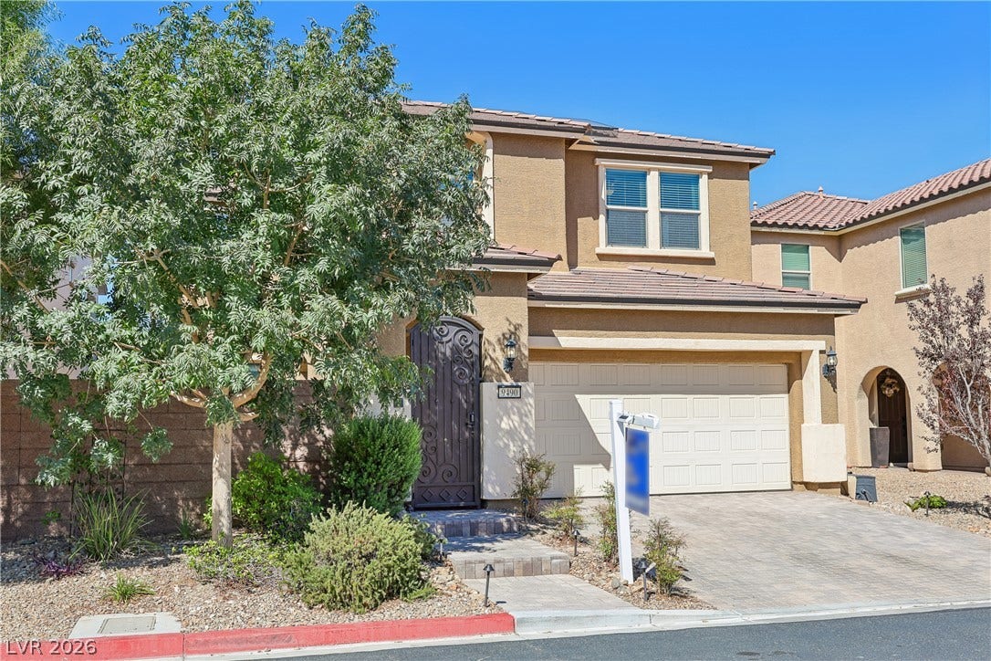 9490 Wild Valley Avenue, Las Vegas, NV 89148 An inviting stucco exterior features tiled roofing, paver driveway, and arched entryway detail.