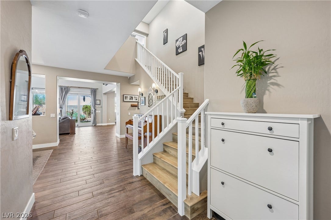 9490 Wild Valley Avenue, Las Vegas, NV 89148 Gleaming wood-look floors guide the eye toward a soaring staircase and open living spaces.
